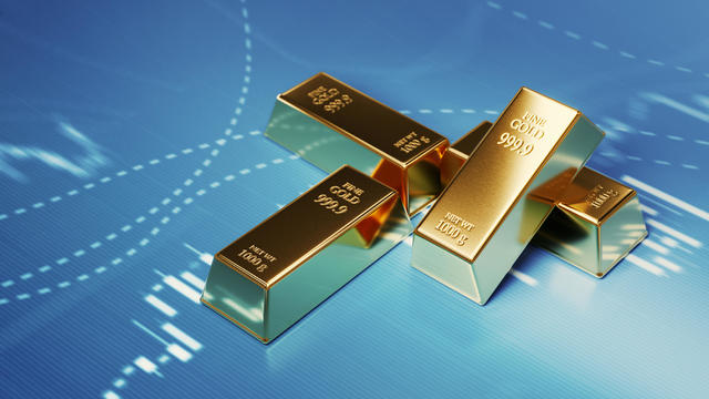Gold Bars Sitting in Front of Bar Graph - Stock Market and Finance Concept 