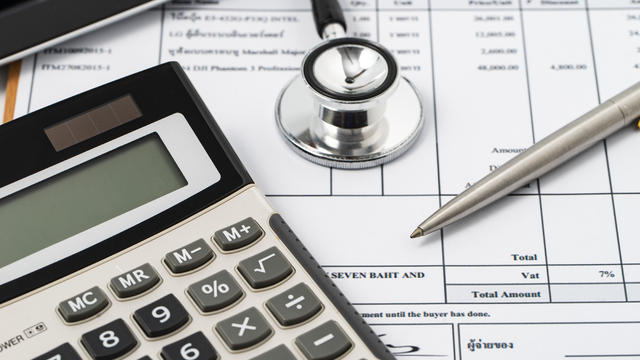 Stethoscope on medical billing statement on table, all text is anonymous 