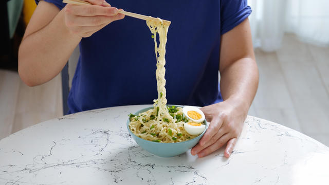 Closeup of person eating cooked instant noodles 